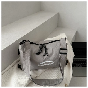 Close-up of FANYISSA light grey nylon dumpling bag with dual zippers and woven pulls