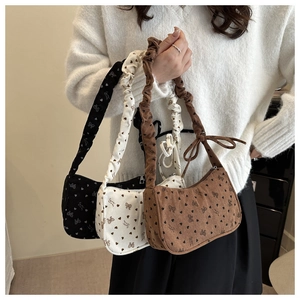 Detail of corduroy texture and bow ties on floral pattern shoulder bags in three colors