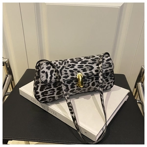 Detail of leopard print shoulder bag with gold metal twist lock on a white book