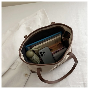 Detail view of large capacity tote bag interior holding tablet, books and umbrella