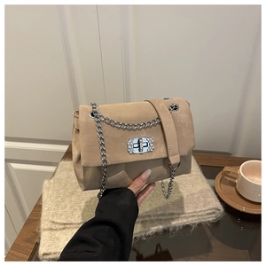 Elegant khaki suede crossbody chain bag with floral rhinestone lock in a cozy setting