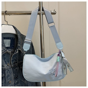 Sac bandoulière bleu clair en demi-lune avec broderie et pendentif tissé
