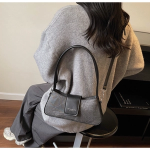 Close-up of stylish grey marble texture baguette bag with black leather shoulder strap