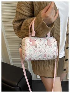 Détail du sac boston plissé blanc avec motifs de dessins animés roses et bandoulière