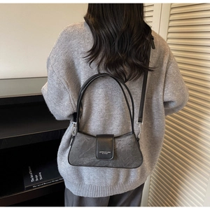 Deep grey stone texture shoulder bag worn under the arm with black leather handles