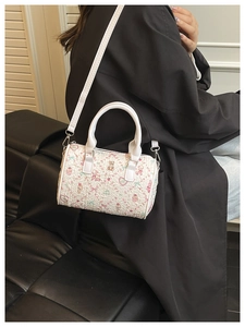 Détail du mini sac polochon blanc avec imprimés fleurs et ours et texture plissée