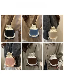 Model wearing various colors of mini bucket bags with pearl handles and chain straps