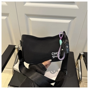 Détail du sac lune en nylon noir avec broderie coeur blanc et cordelette colorée