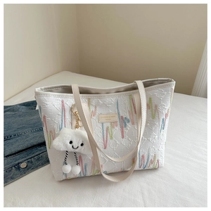Dettaglio del ricamo a onde colorate su una borsa tote grande con ciondolo a nuvola