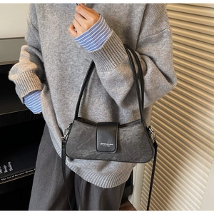Detailed side view of gray matte baguette bag with black leather flap and silver hardware