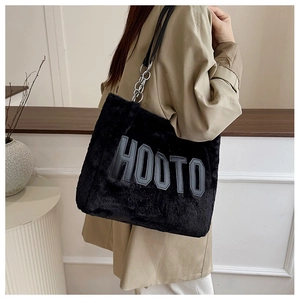 Detail of black plush tote bag with silver chain strap and grey HOOTO lettering
