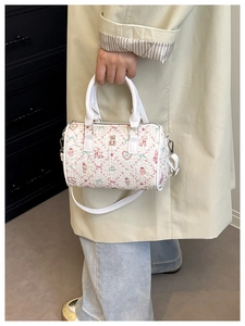 Détail de l'imprimé ours mignon et texture plissée 3D sur le sac Boston blanc
