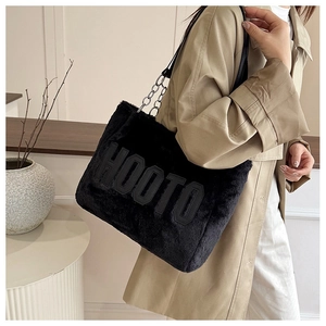 Detail of black faux fur tote bag with HOOTO patch and metallic chain strap on shoulder