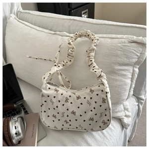 Detail of white corduroy shoulder bag with heart patterns and ruffled cloud strap
