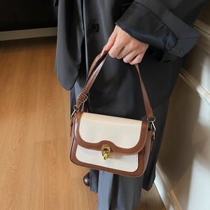 Retro cream white and brown contrast square bag with gold buckle on a chic model