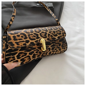 Detail shot of the leopard print faux leather baguette bag with a gold oval lock buckle