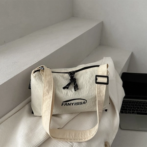Minimalist beige nylon shoulder bag with FANYISSA logo on a modern cement background