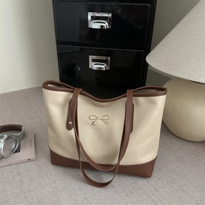 Minimalist large-capacity cream tote bag with brown leather accents and bow buckle details