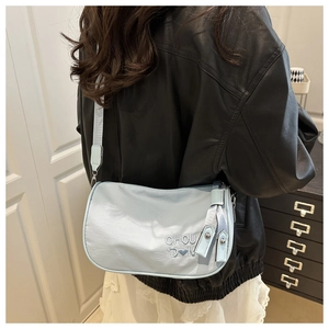 Détail du sac bandoulière bleu clair avec broderie de lettres et motif cœur en nylon