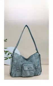 Detail of teal vintage hobo bag with front pocket, textured faux leather and rivets