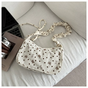 Detail of corduroy shoulder bag with heart bow pattern and ruffled strap texture