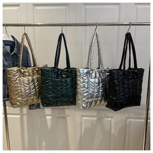 Quilted puffer tote bags in gold, dark green, silver, and black with metallic finish