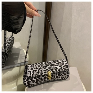 Close-up of leopard print shoulder bag with elegant oval gold metallic buckle lock