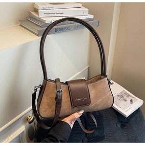 Detail of retro brown color-block baguette bag with mixed fabric and leather textures