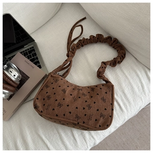 Detail of dark brown corduroy tote bag with heart patterns and ruched handle design