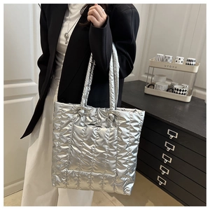 Detail of silver metallic quilted tote bag with padded texture and large capacity