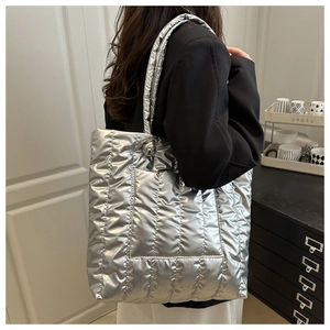 Quilted metallic silver tote bag with padded stitch detail shown on female model