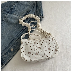 Detail of white corduroy tote bag with brown heart patterns and ruched handle
