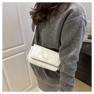 Close-up of a white rectangular crossbody bag with glossy leather and brand logo