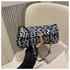 Close-up of leopard print baguette bag featuring a gold rectangular metal twist lock