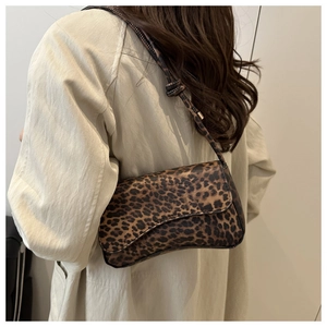 Close-up of leopard print baguette bag with slim shoulder strap and stylish knot detail