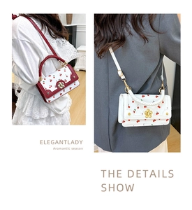 Detail showing cherry print handbags with gold flower buckles and woven texture handles