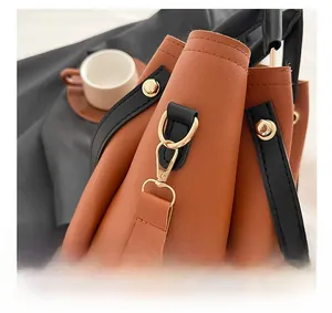 Close-up of golden hardware accessories and two-tone faux leather stitching on handbag