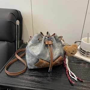 Fashionable denim drawstring bucket bag with leather accents and bear charm for women