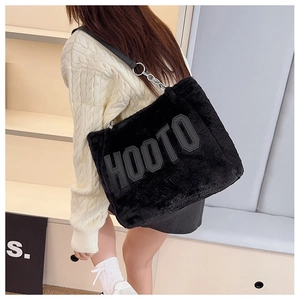 Detail of black fuzzy tote bag with HOOTO patch and chain shoulder strap on model