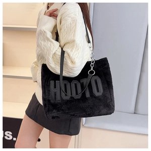 Detail of black fuzzy tote bag with HOOTO letter patch on textured lamb wool fabric