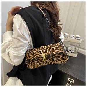 Close-up of leopard print underarm bag featuring a metallic oval gold buckle closure