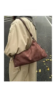 Rust brown suede hobo bag shown on model for a stylish autumnal streetwear look