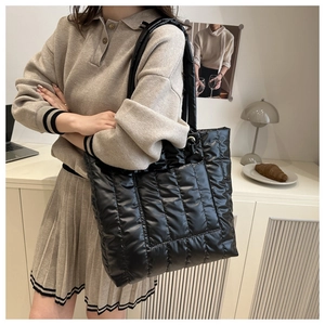 Detailed view of black quilted puffer tote bag with soft padded texture and spacious design