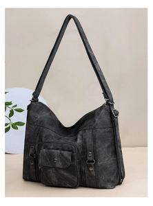 Macro detail of vintage grey canvas shoulder bag with functional pockets and metal studs