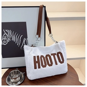Close-up of white plush tote bag featuring HOOTO embroidery and leather chain strap