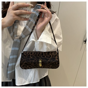 Macro detail of leopard print shoulder bag featuring a premium gold metallic swivel lock