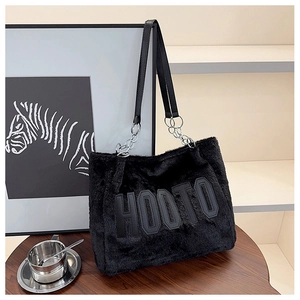 Detail of black faux fur tote bag with HOOTO leather lettering and metal chain strap