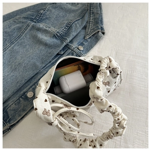 Interior capacity of white corduroy mini bag with bow prints and items inside