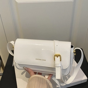 Minimalist white patent leather crossbody bag with adjustable strap and gold buckle hardware