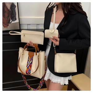 Detail of four-piece cream tote bag set with brown handles and ethnic woven strap